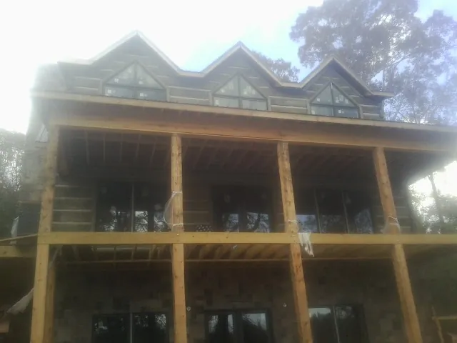 Dormers and porch framing on a large log home under construction — Roof Coating work by our crew in Meriden