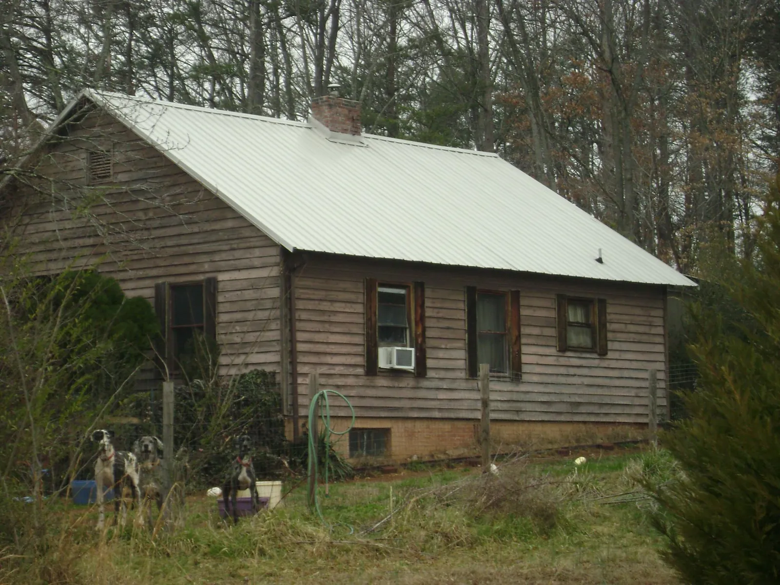 White metal roof on an old wood sided farmhouse, from a Metal Roof Installation job in Meriden